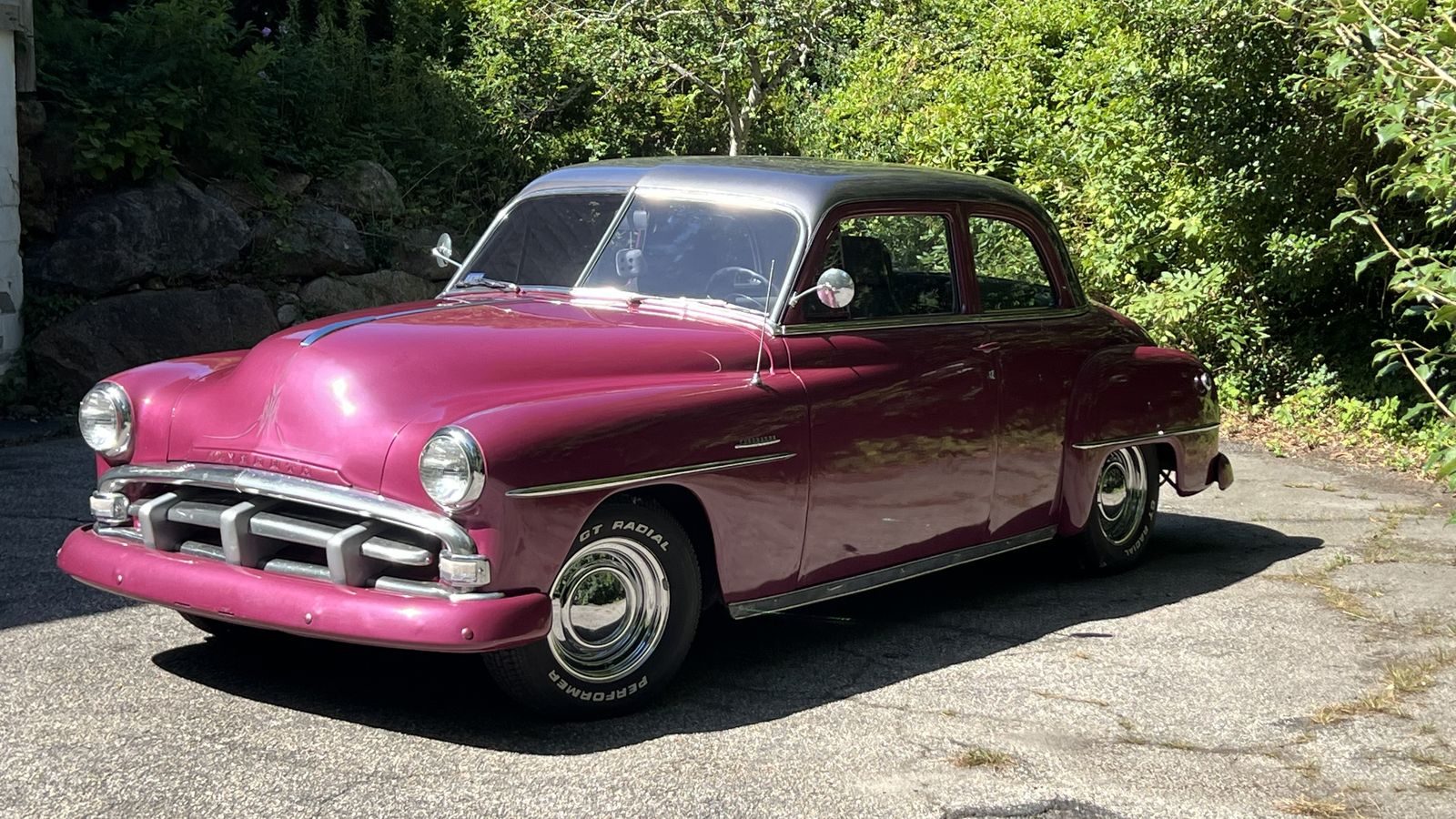 1951 Plymouth Cranbrook in magenta parked on a driveway