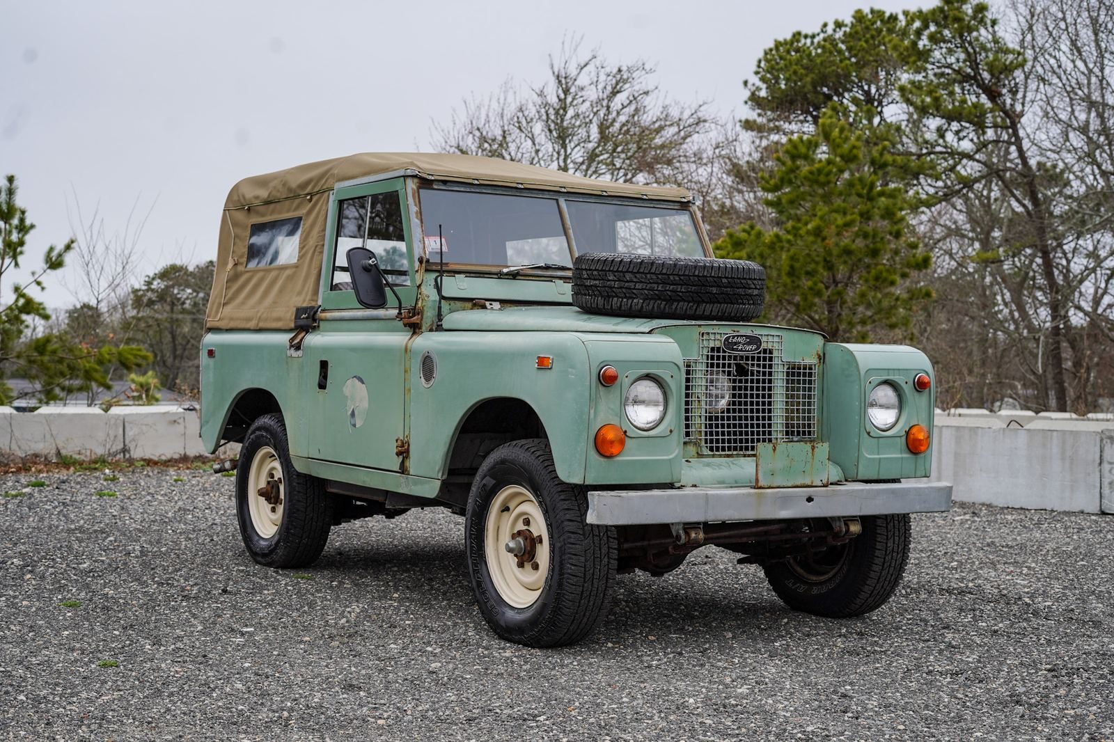 Teal 1971 Land Rover Series III parked on gravel